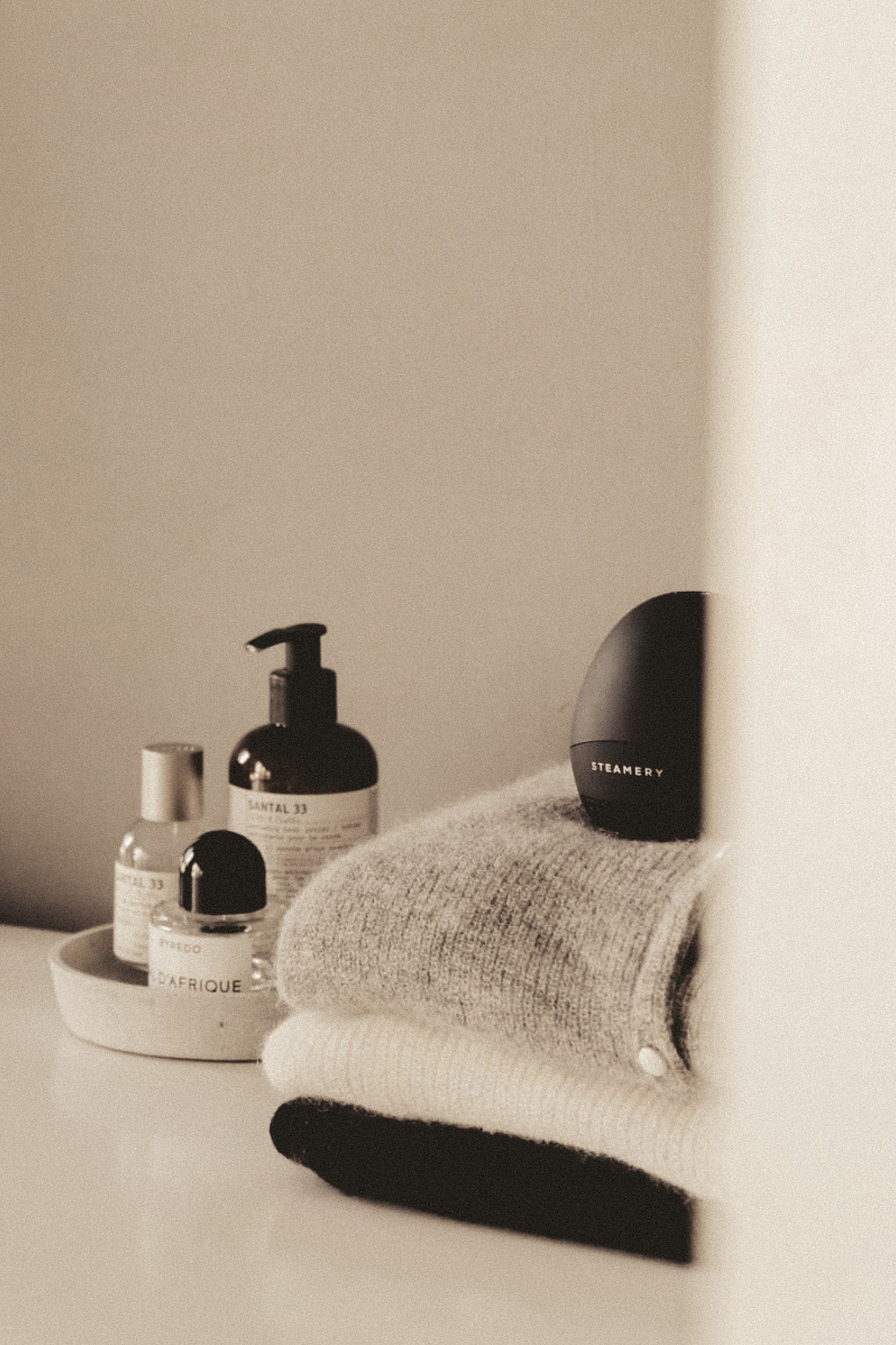 Black fabric shaver on top of a stack of folded garments