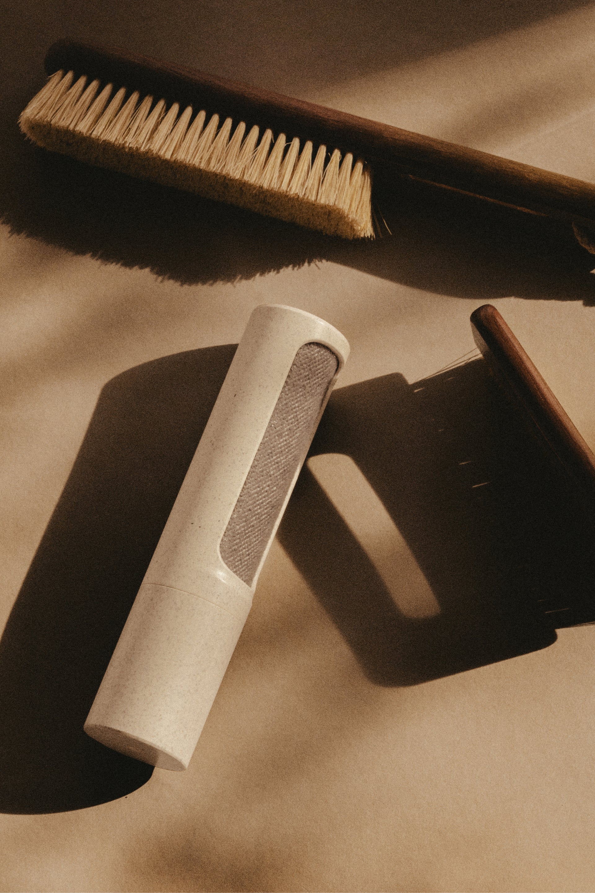 Set of clothing brushes on a textured beige surface