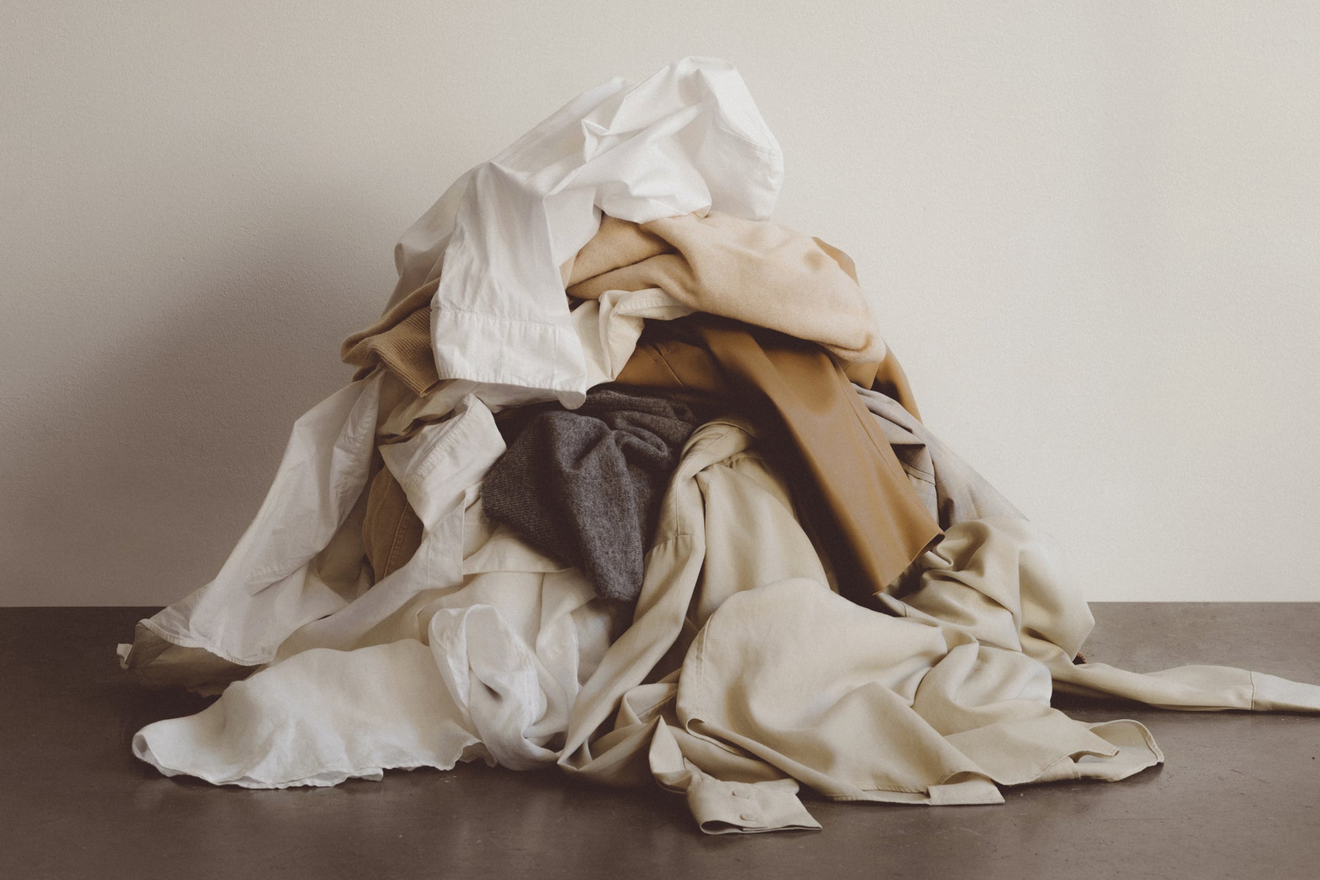 Pile of crumpled clothes on a neutral background